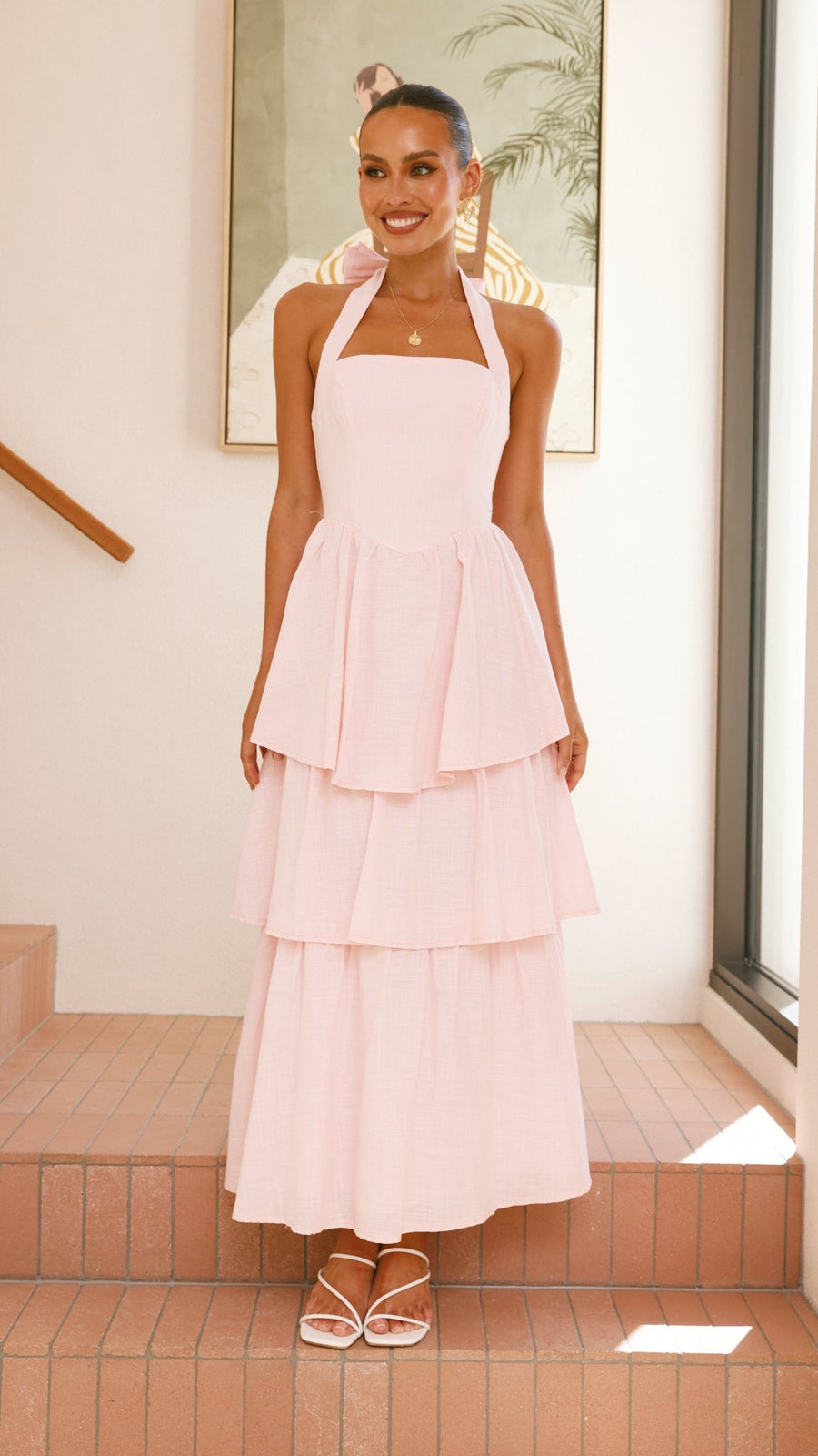 Pink crepe tiered maxi dress with halter neckline and tie-up bow back
