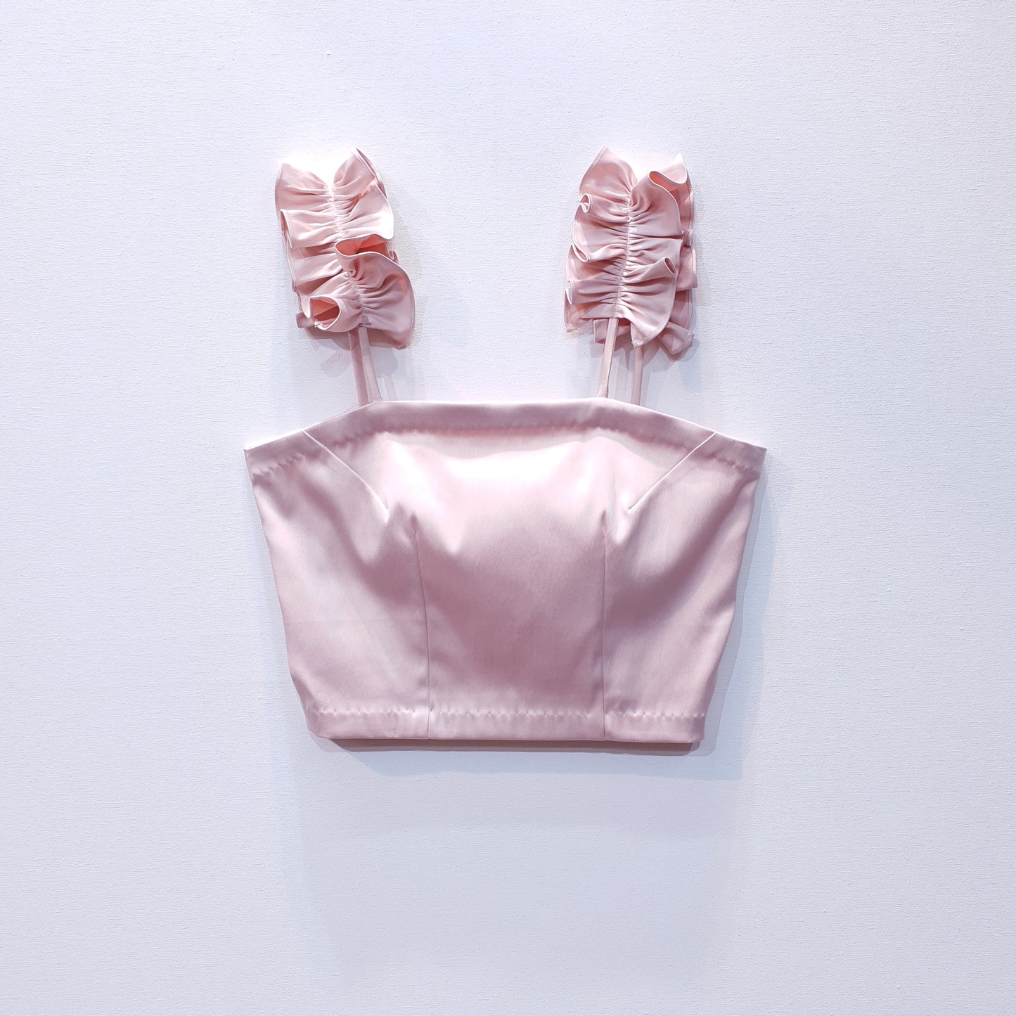 Pink duchess satin top with ruffle straps on a white background