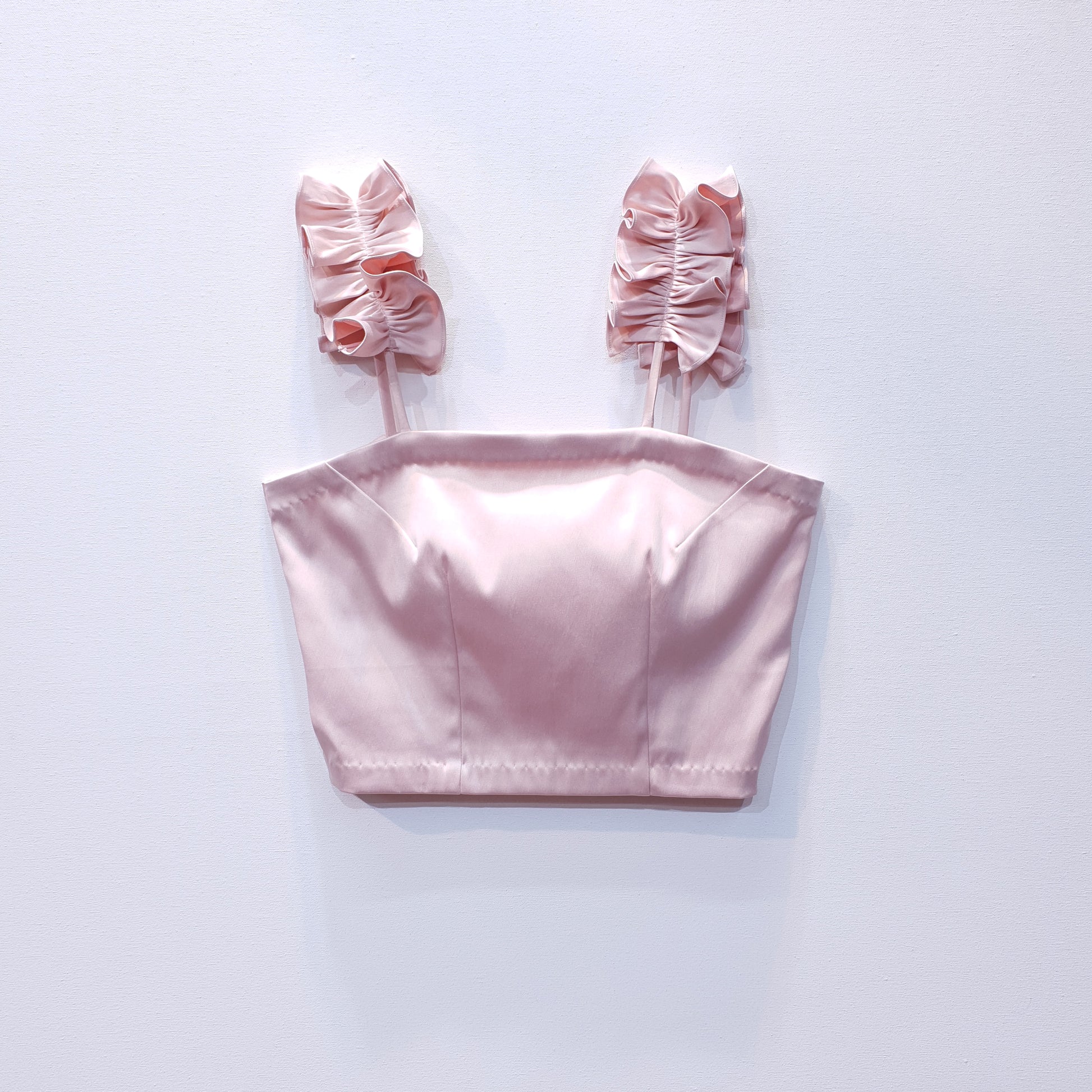 Pink duchess satin top with ruffle straps on a white background