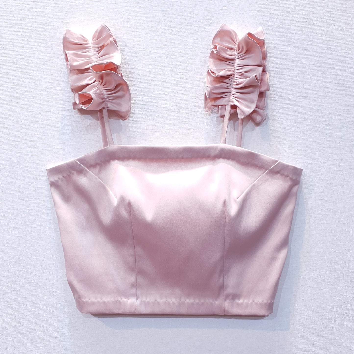 Pink duchess satin top with ruffle straps on a white background