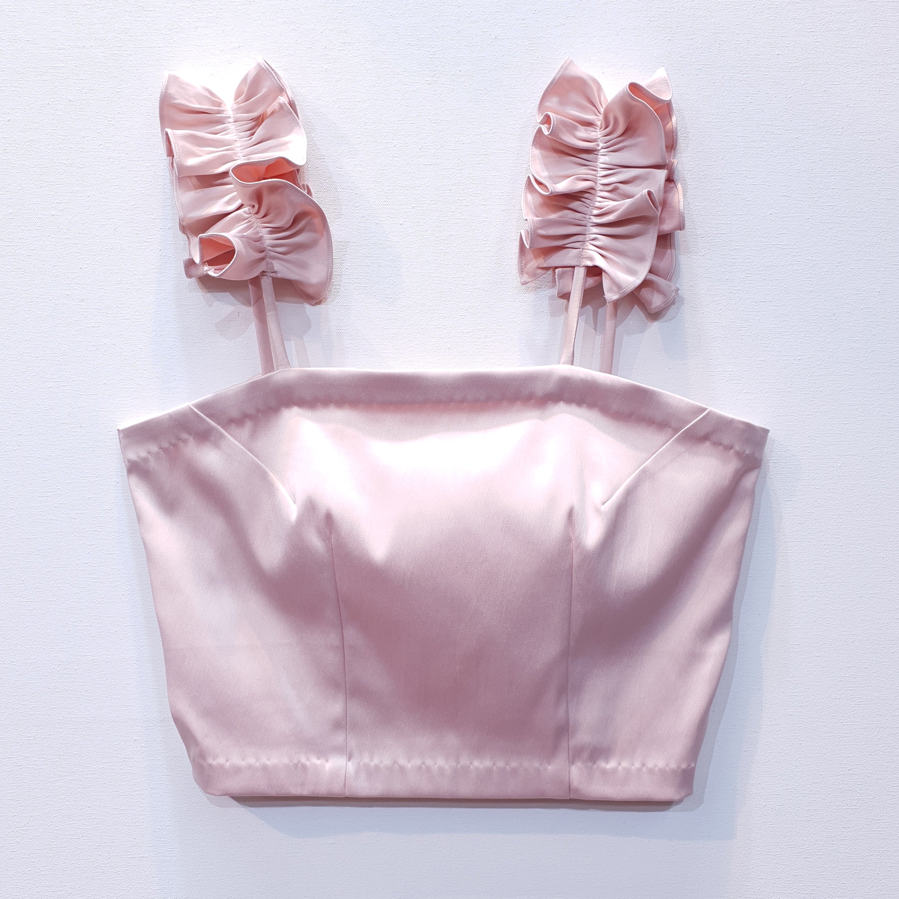 Pink duchess satin top with ruffle straps on a white background