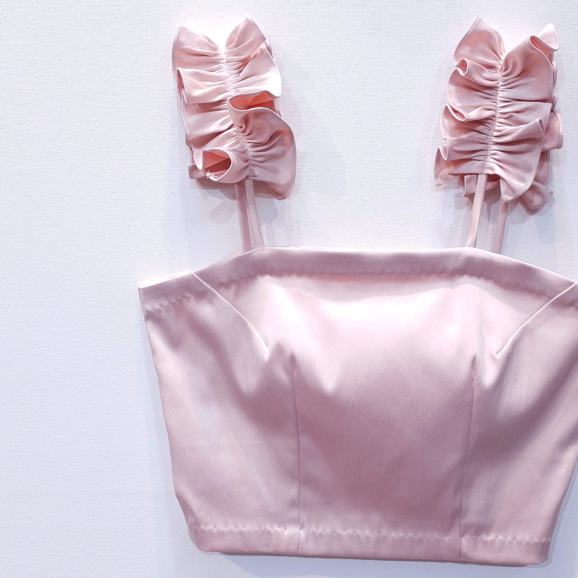 Pink duchess satin top with ruffle straps on a white background