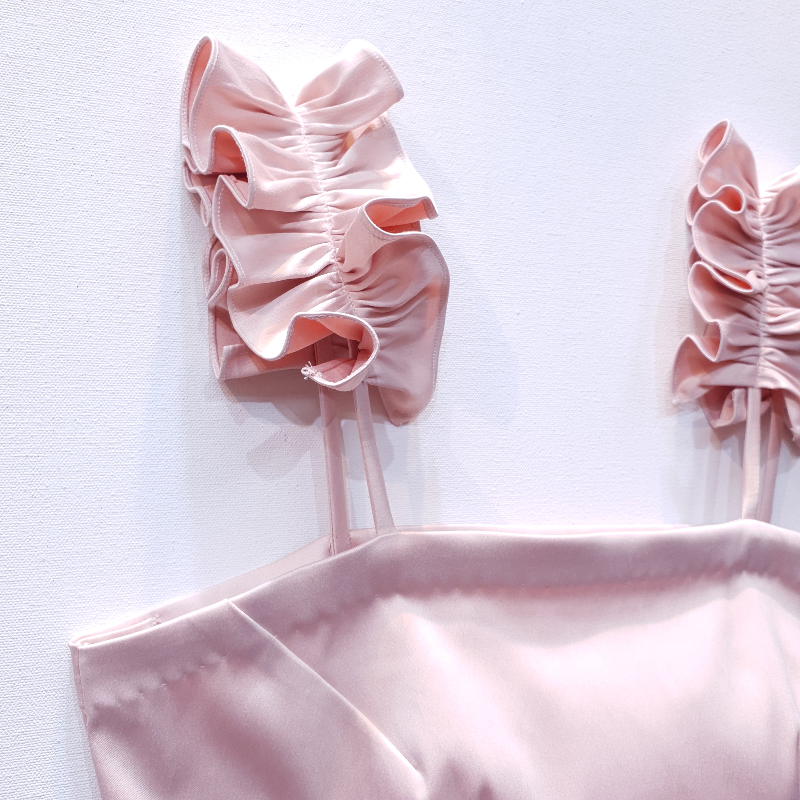 Pink duchess satin top with ruffle straps on a white background