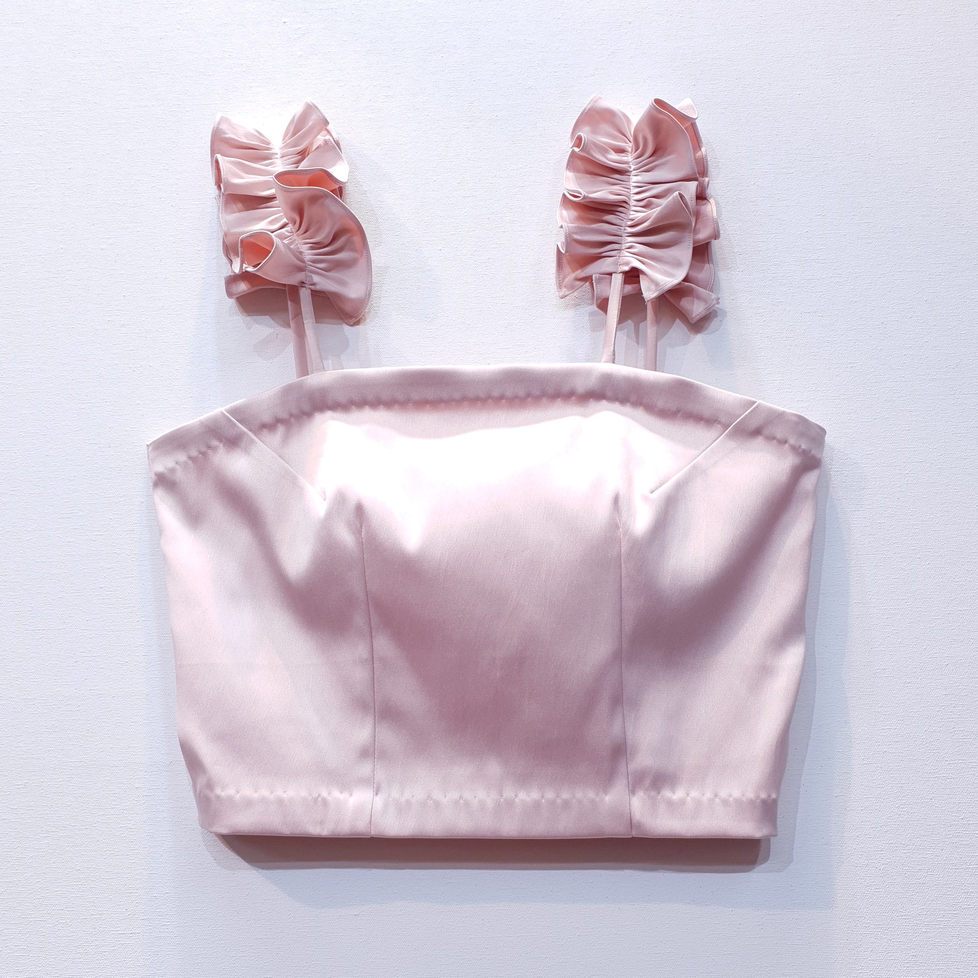 Pink duchess satin top with ruffle straps on a white background