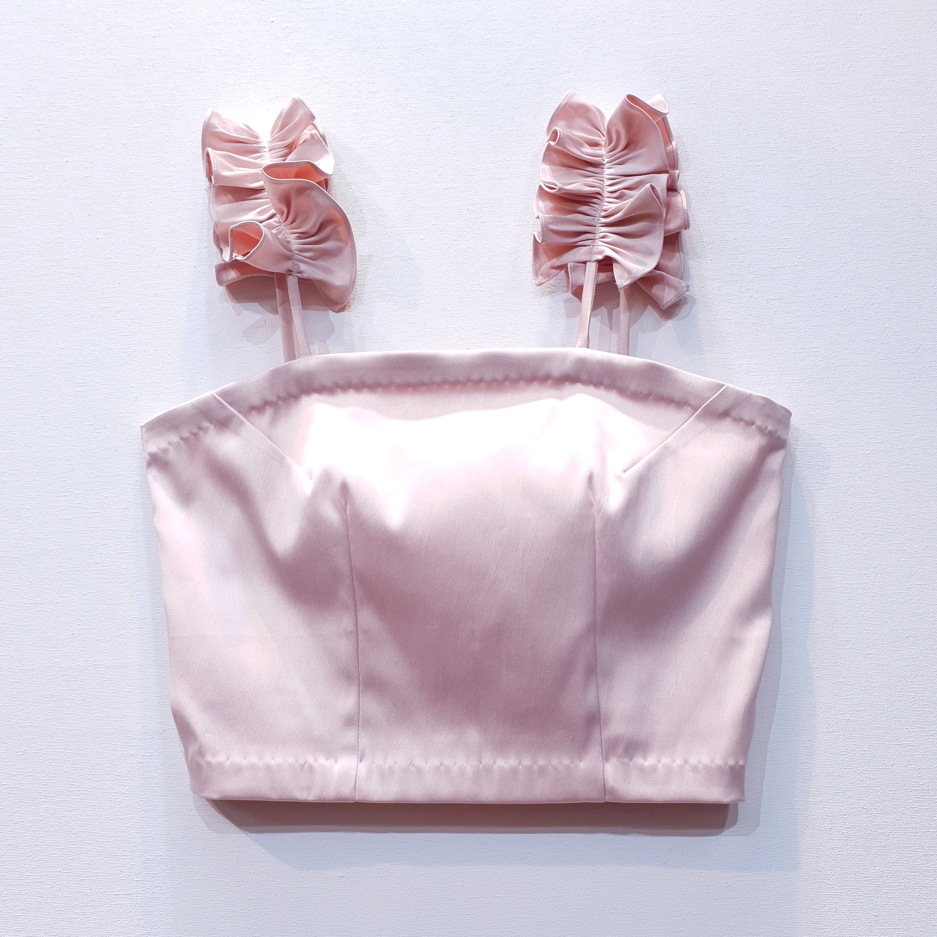 Pink duchess satin top with ruffle straps on a white background