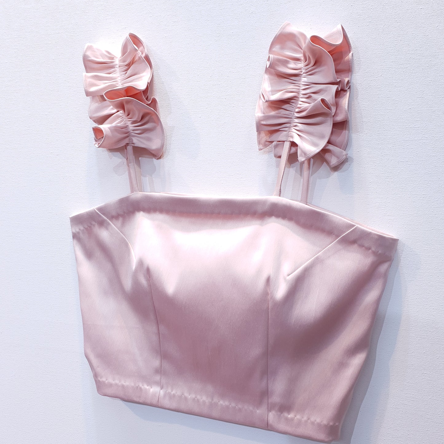 Pink duchess satin top with ruffle straps on a white background