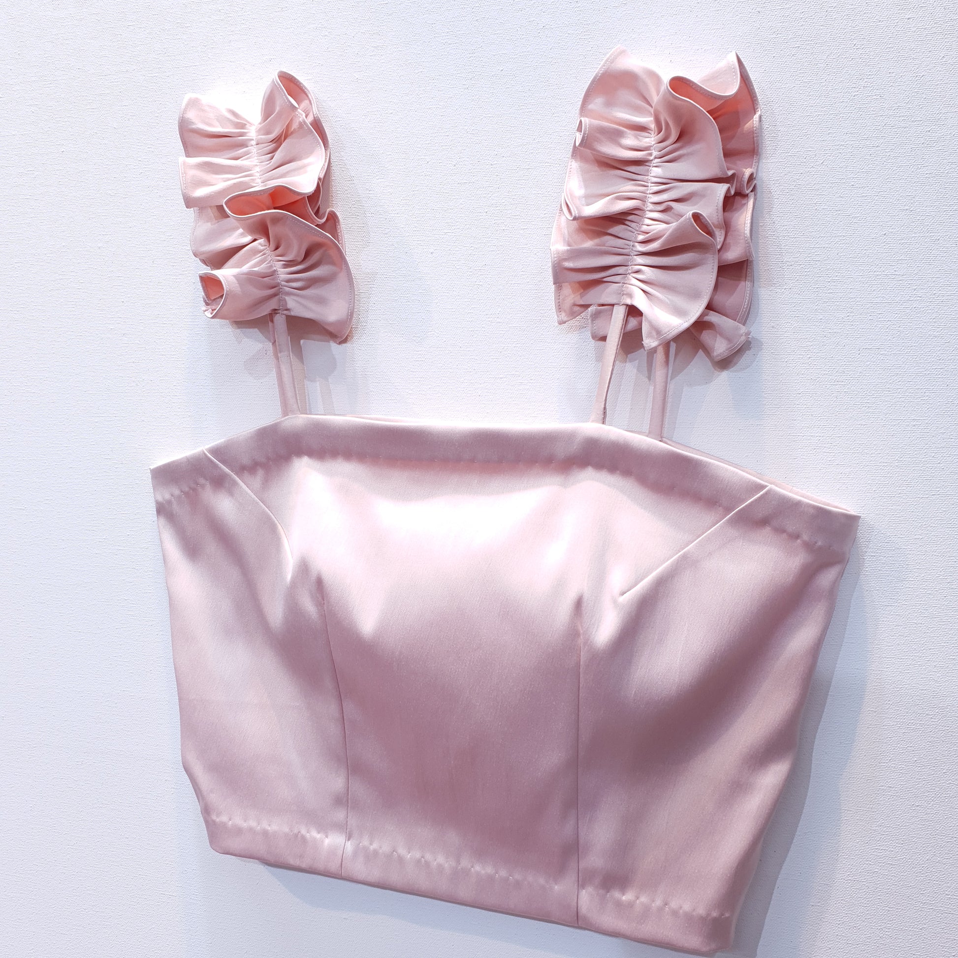 Pink duchess satin top with ruffle straps on a white background