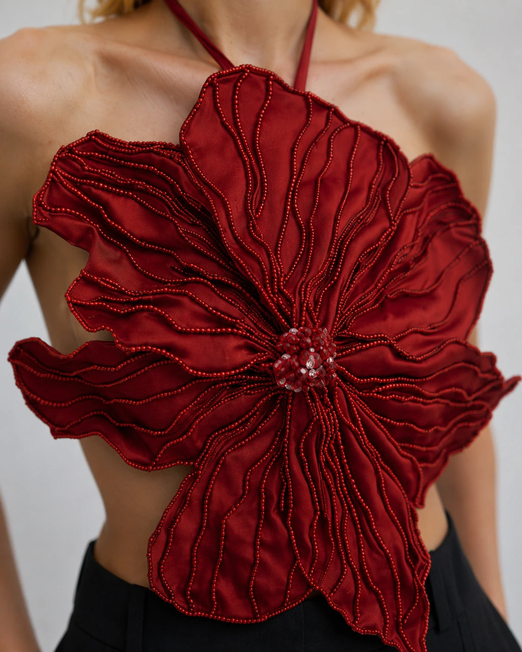 Top in raso rosso con applicazioni floreali 3D e ricamo di perle
