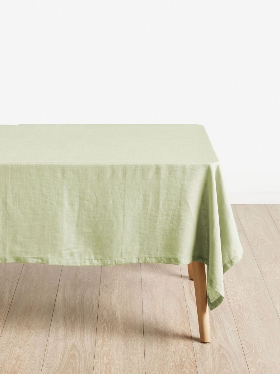 Green tablecloth on a wooden table with a white background