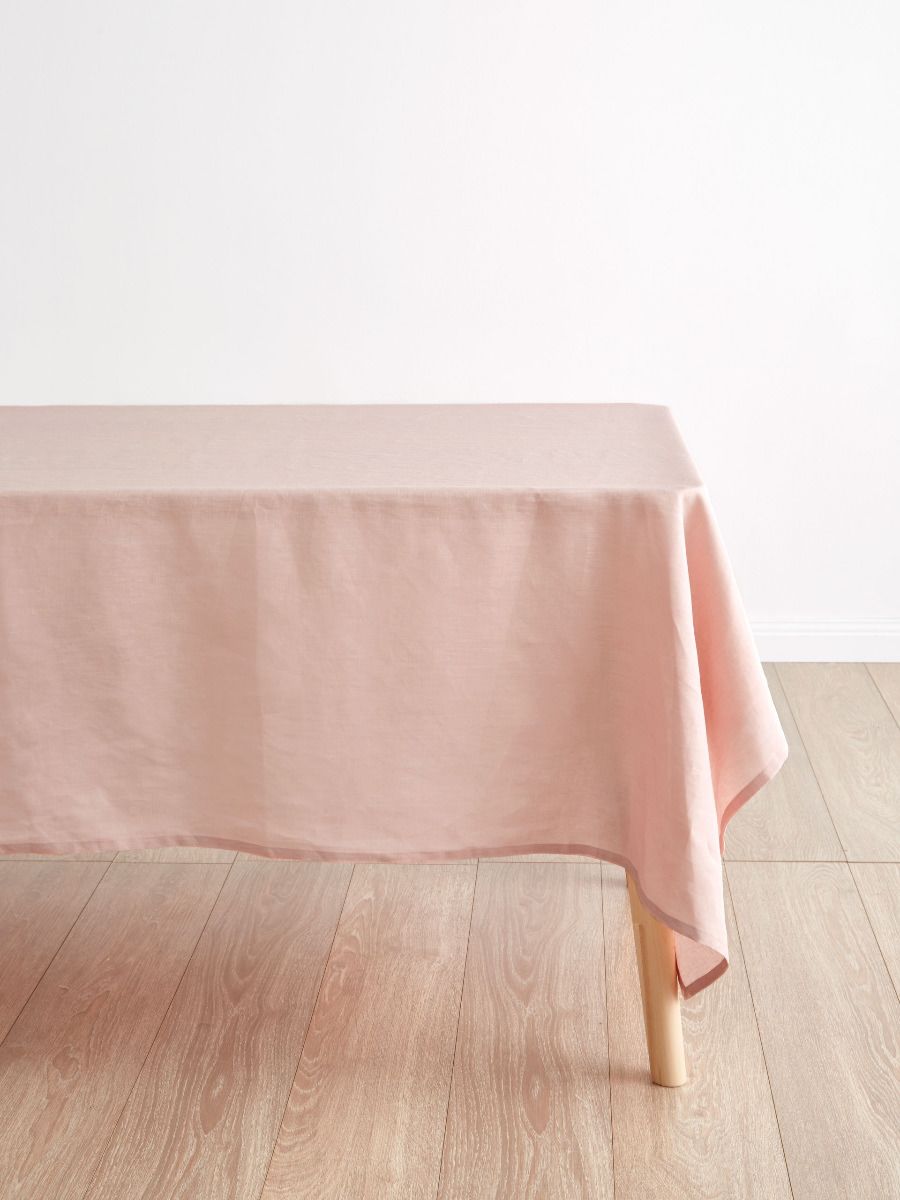 Peach tablecloth on a wooden table with a white background