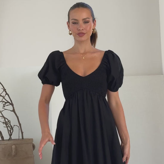 Black linen mini dress with puff sleeves, sweetheart neckline, and smocked back