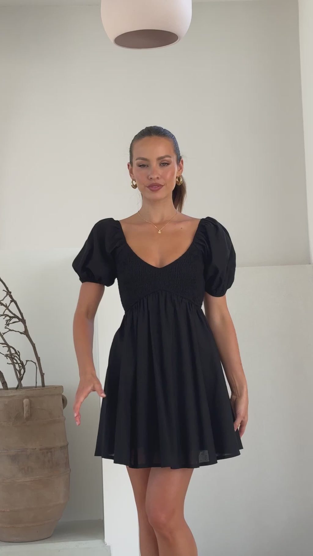 Black linen mini dress with puff sleeves, sweetheart neckline, and smocked back