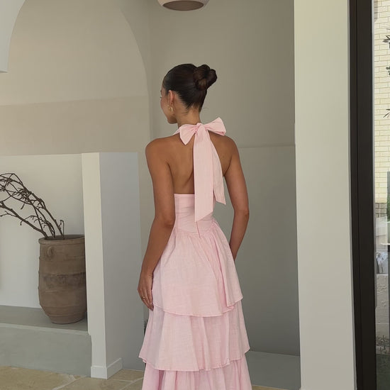 Pink crepe tiered maxi dress with halter neckline and tie-up bow back