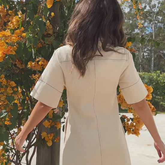 White denim button-down mini dress with short sleeves and side pockets