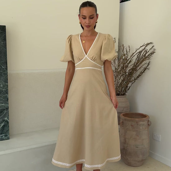 Beige linen maxi dress with puff sleeves, lace trim, and V-neckline