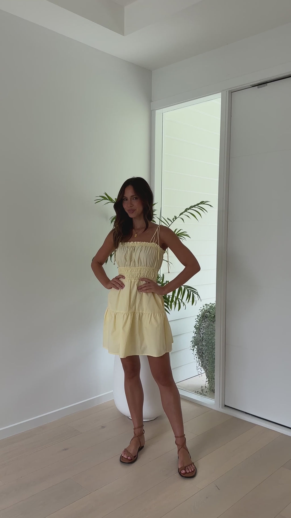 Lemon yellow cotton mini dress with smocked waist, tie straps, and pockets