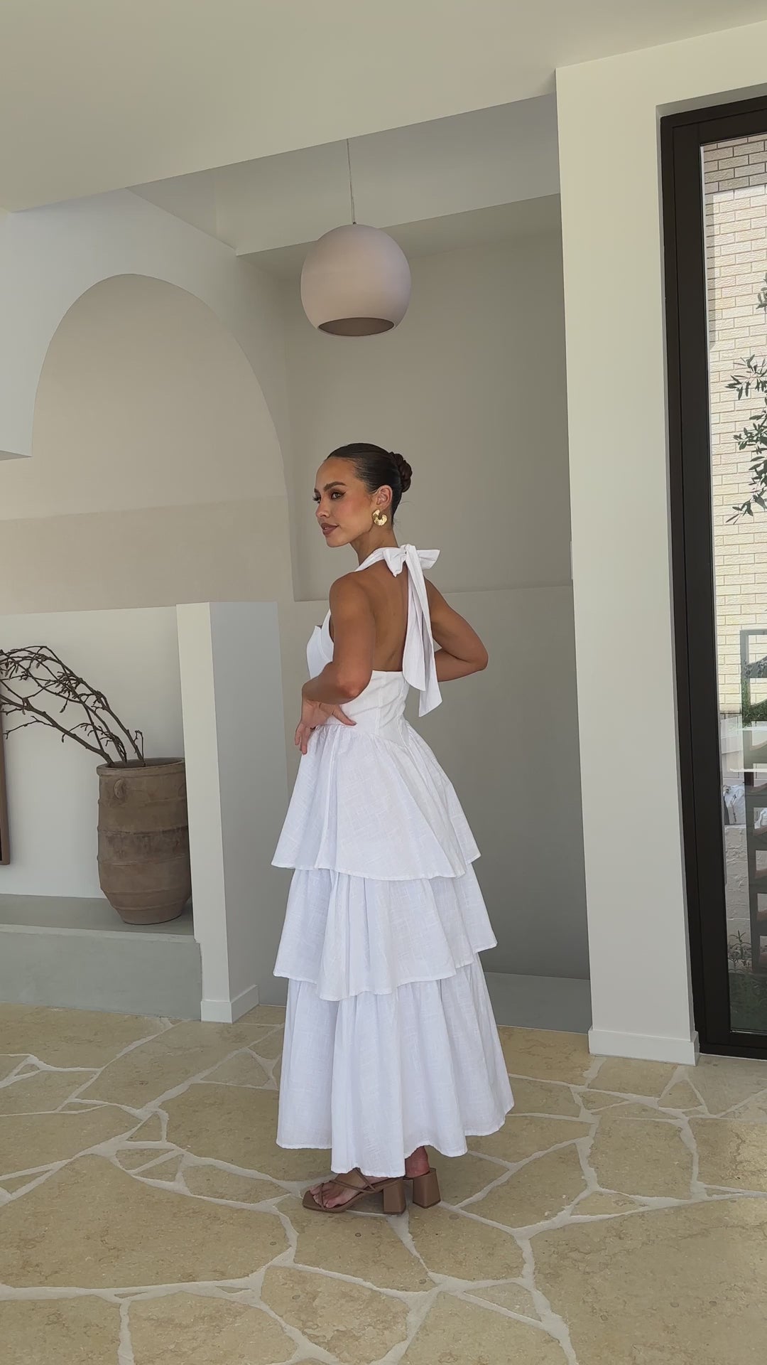 White crepe tiered maxi dress with halter neckline and back tie-up bow