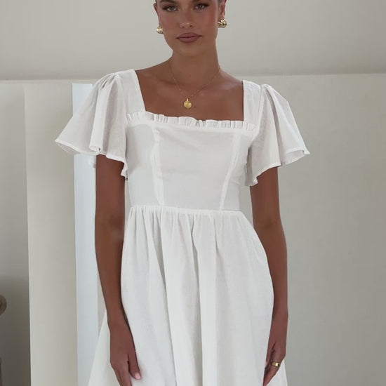 White linen mini dress with flutter sleeves, square neckline
