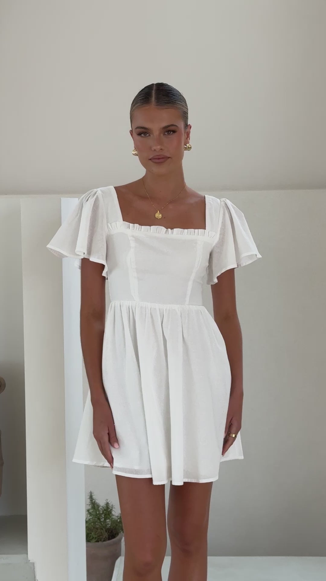White linen mini dress with flutter sleeves, square neckline