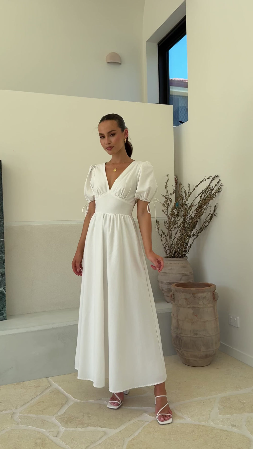 White linen maxi dress with puff sleeves, V-neckline, and smocked back