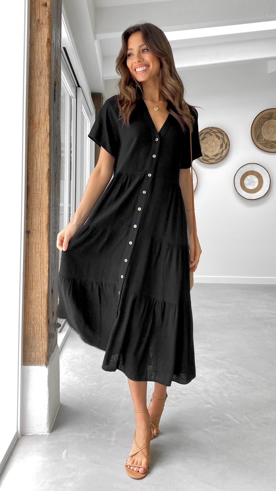 Black linen midi dress with short sleeves, tiered skirt, and button-down front