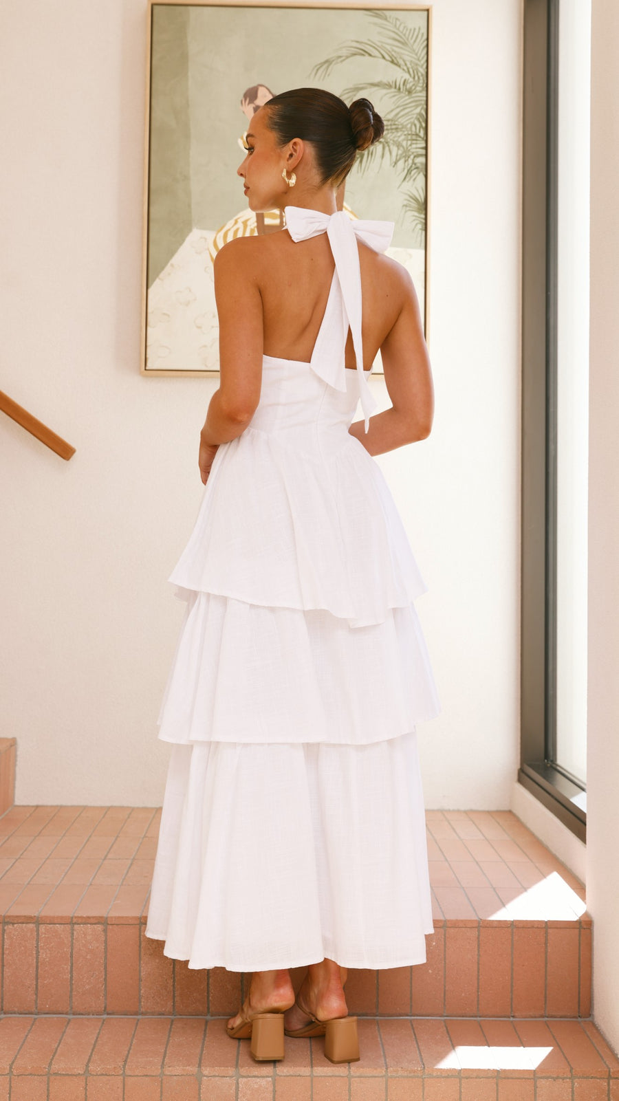 White crepe tiered maxi dress with halter neckline and back tie-up bow