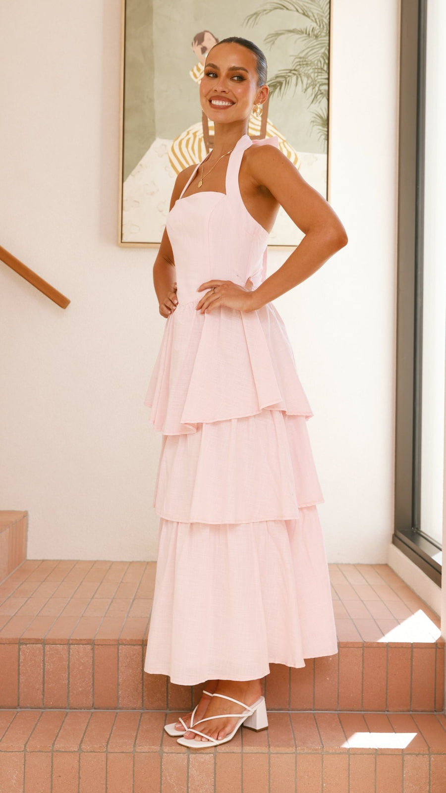 Pink crepe tiered maxi dress with halter neckline and tie-up bow back