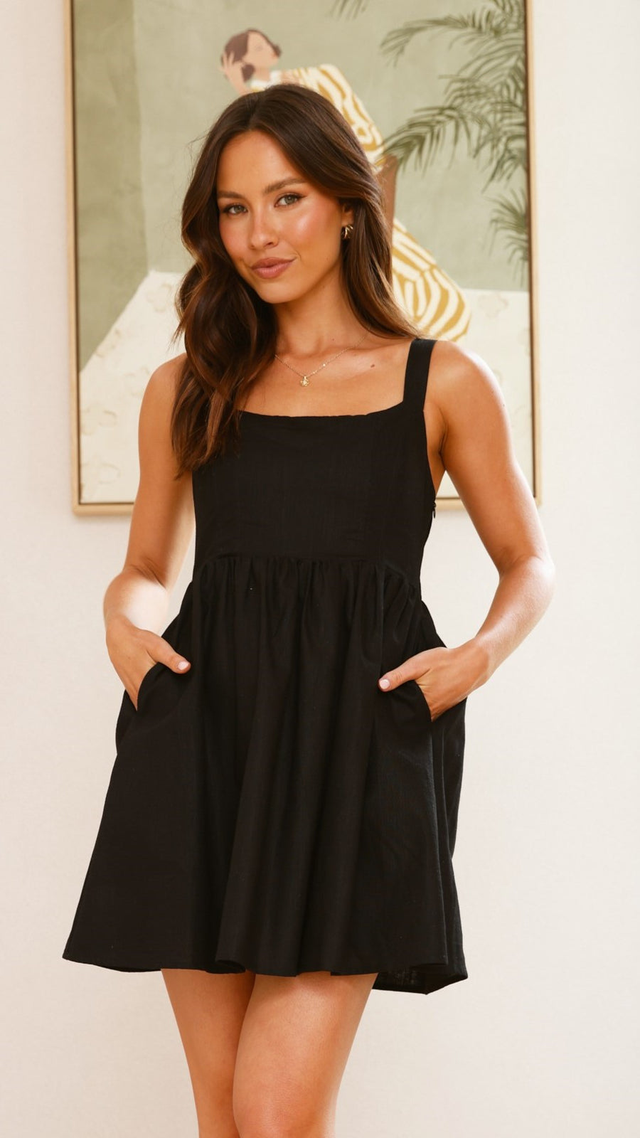 Black linen mini dress with square neckline, sleeveless straps, and smocked back