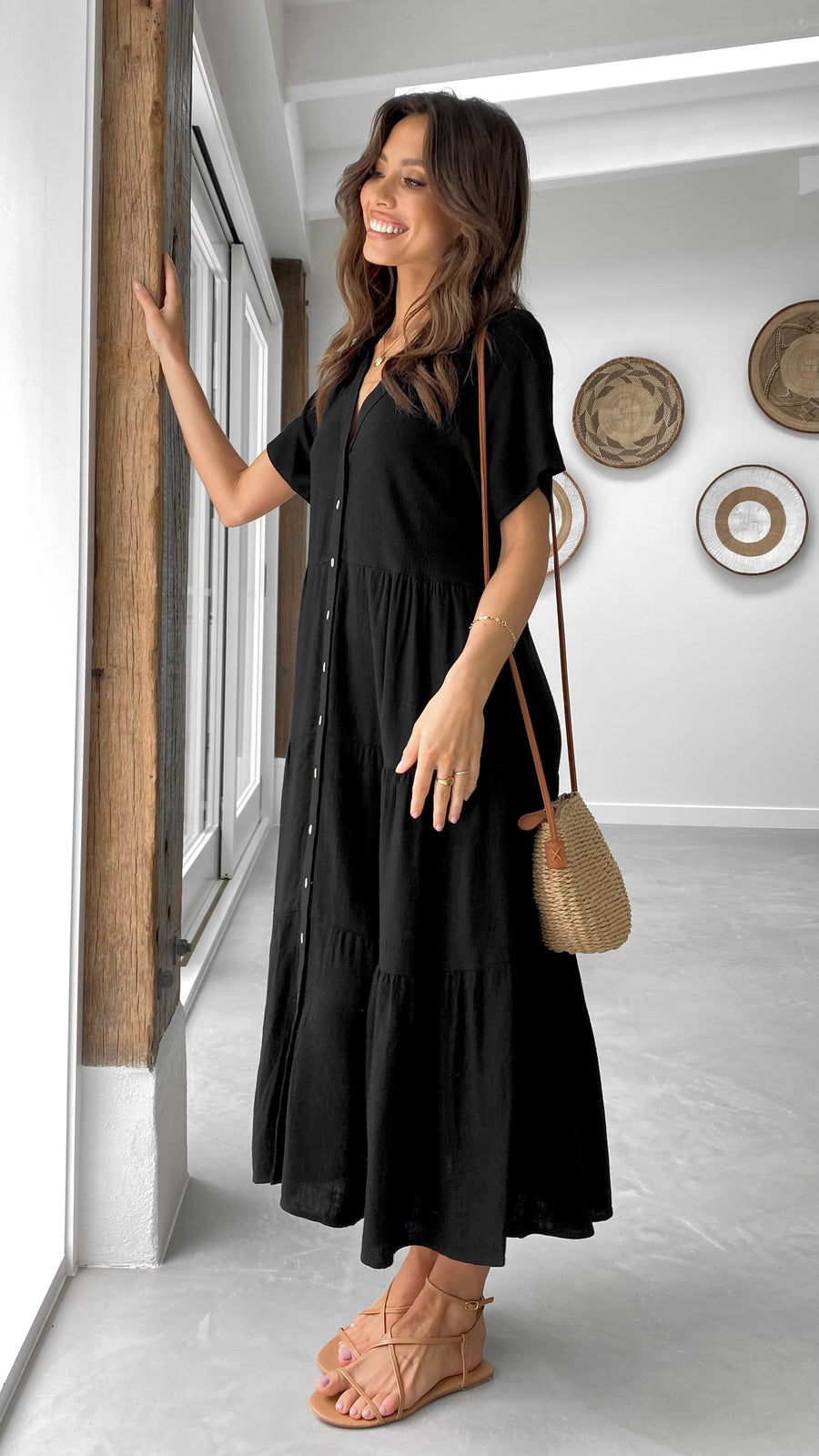 Black linen midi dress with short sleeves, tiered skirt, and button-down front