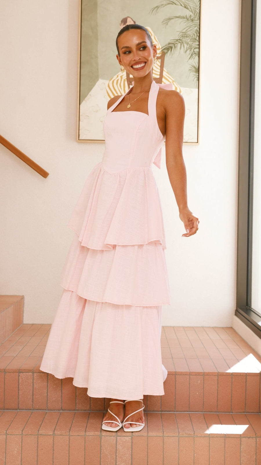Pink crepe tiered maxi dress with halter neckline and tie-up bow back
