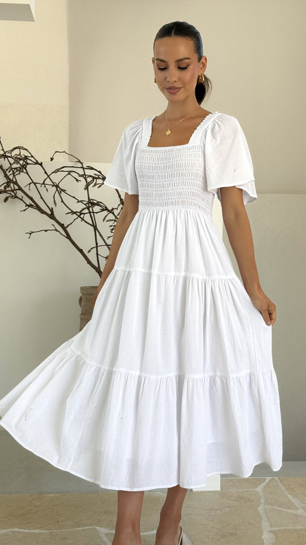 White midi dress with smocked front and back, puff sleeves, and tiered skirt