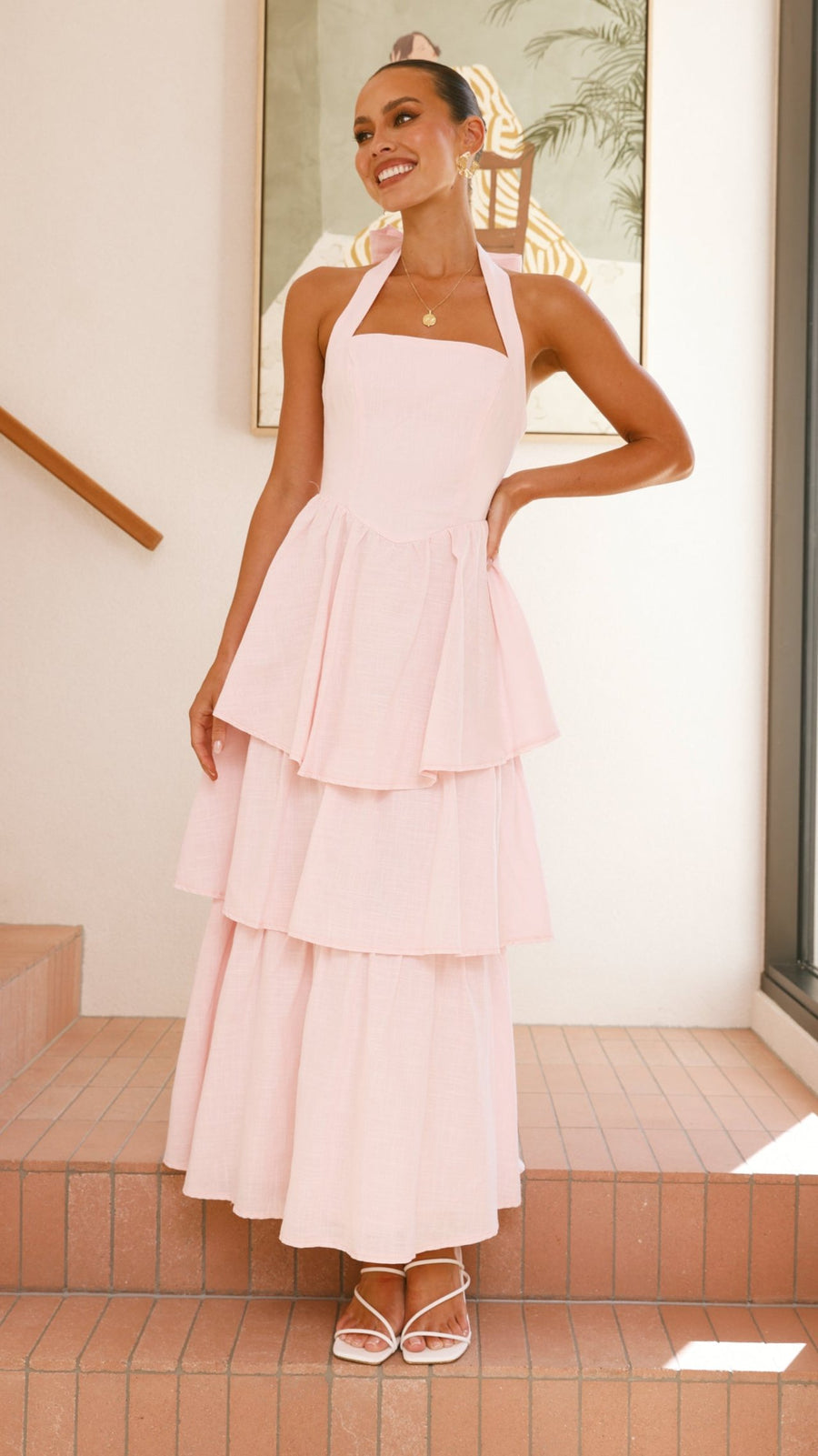 Pink crepe tiered maxi dress with halter neckline and tie-up bow back