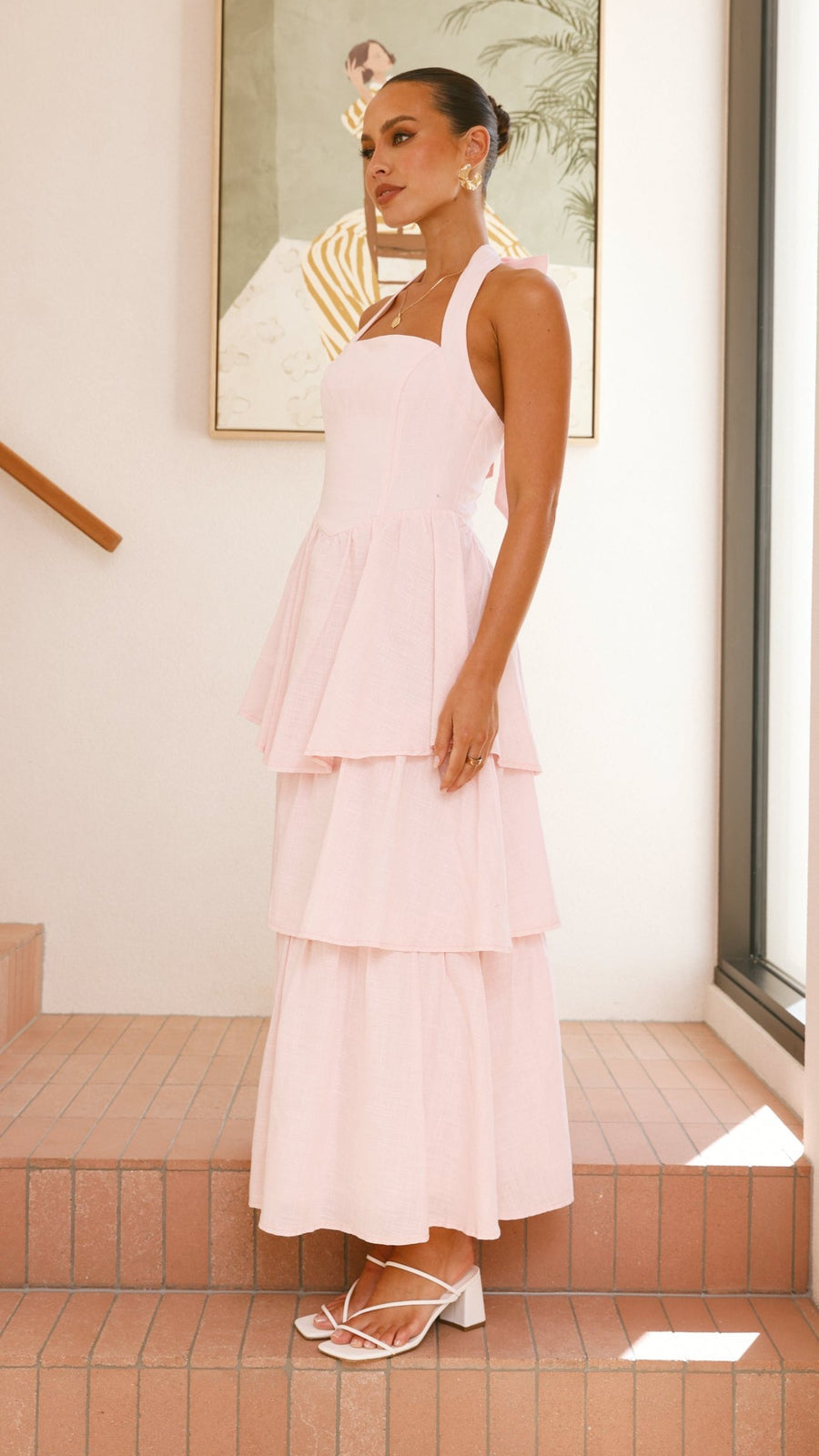 Pink crepe tiered maxi dress with halter neckline and tie-up bow back