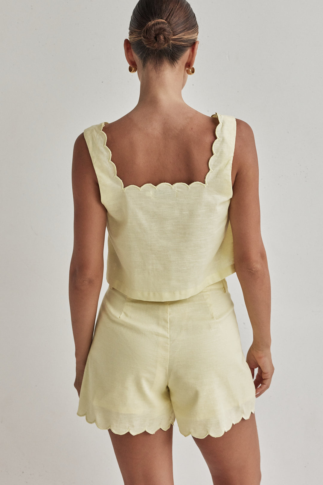 Butter yellow linen crop top with scalloped hem and sleeveless design